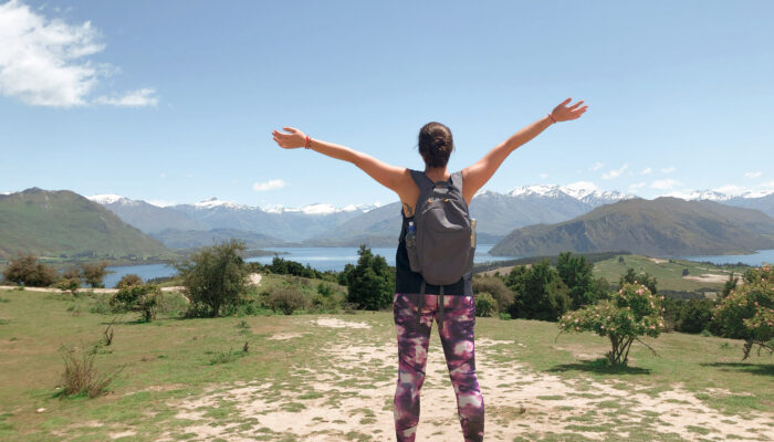 Woman with arms wide open looking at a mountain view