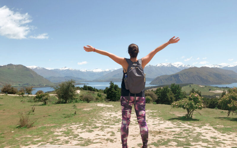 Woman with arms wide open looking at a mountain view