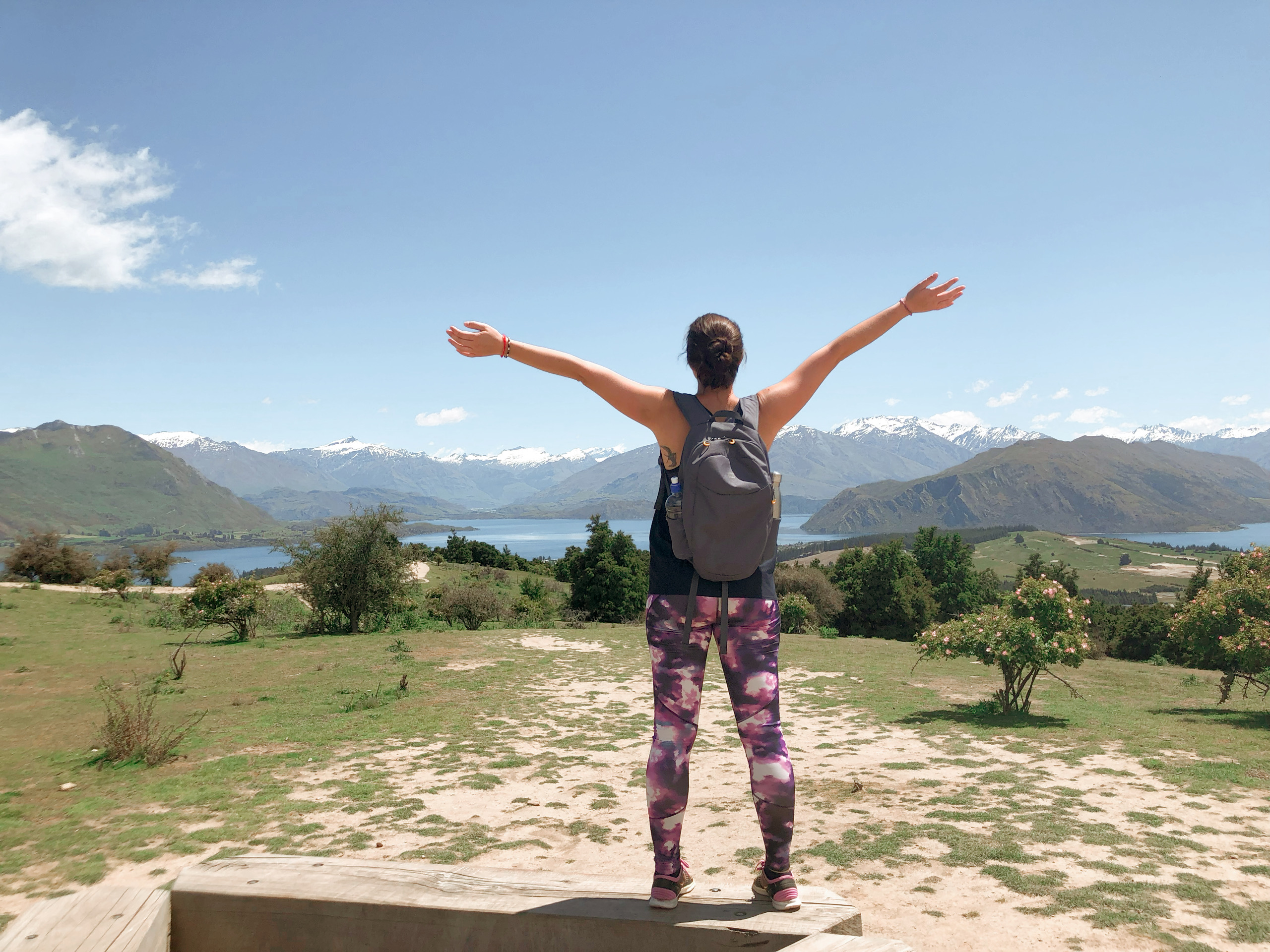 Woman with arms wide open looking at a mountain view