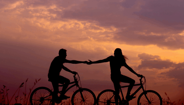 Romantic bike ride holding hands