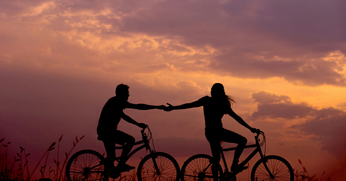 Romantic bike ride holding hands